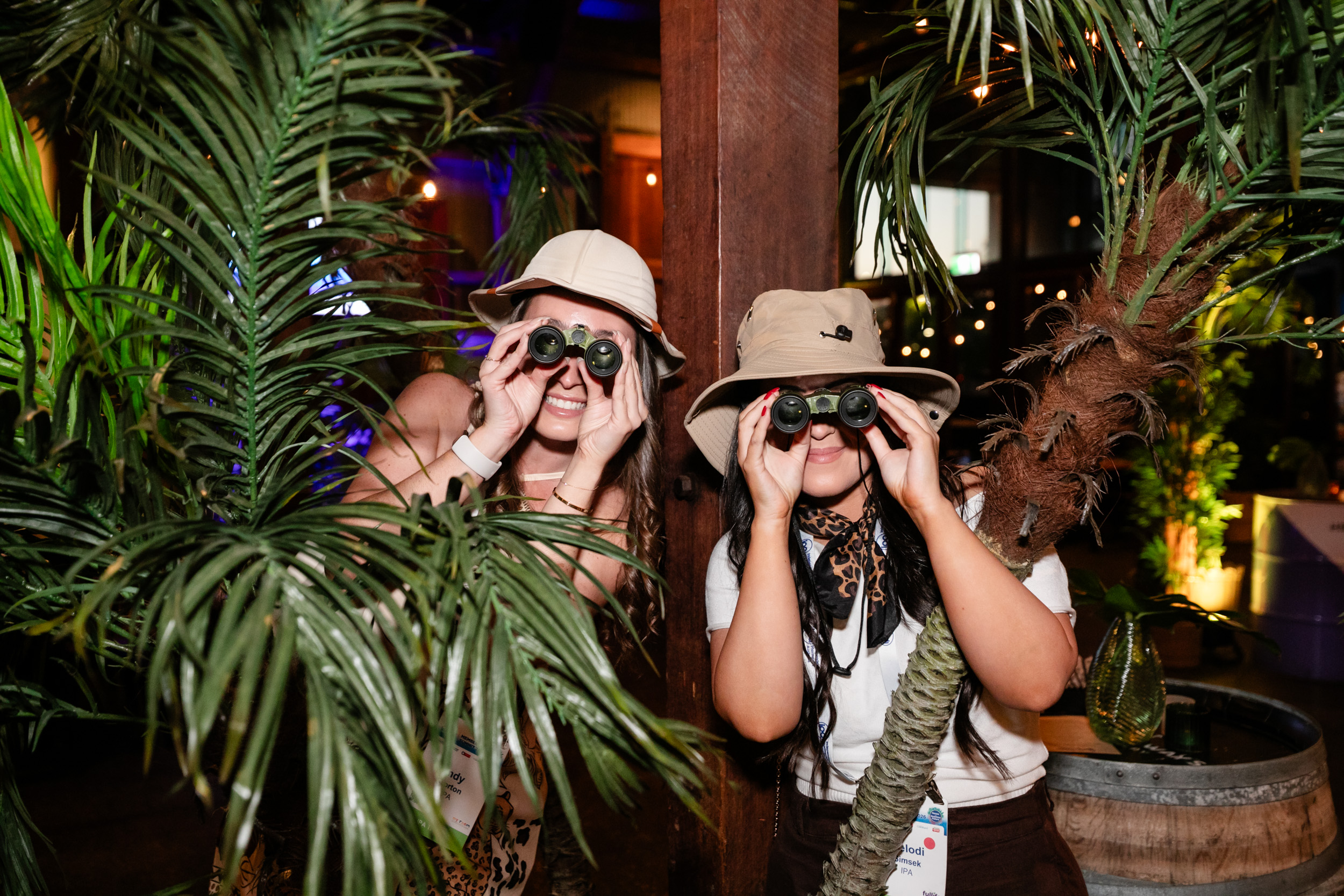 Two delegates looking through safari binoculars at the event