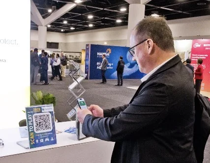 A wider view of a delegate scanning at an exhibitor stand